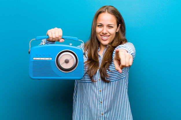 Mujer joven con una radio vintage azul