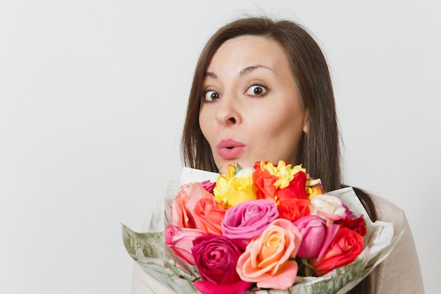 Mujer joven con ramo de flores rosas hermosas aisladas sobre fondo blanco de cerca. Copie el espacio para publicidad. Con lugar para texto. Concepto de día de San Valentín o día internacional de la mujer