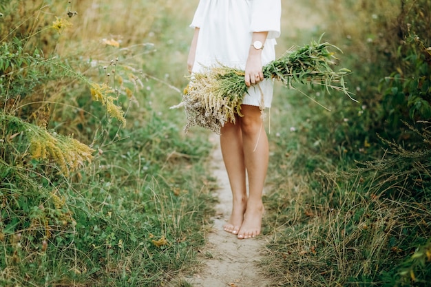 Mujer joven con un ramo de flores silvestres