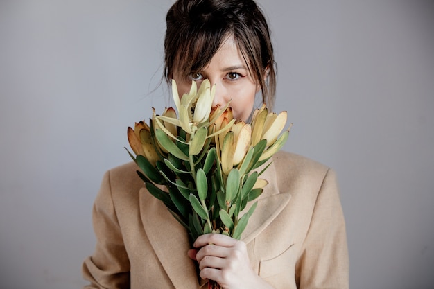 Mujer joven con ramo de leucadendron.