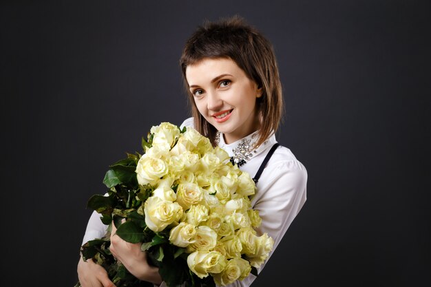 Mujer joven con ramo de rosas blancas