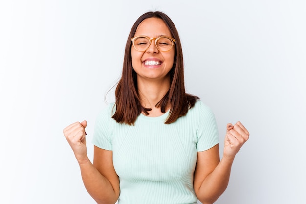 Mujer joven de raza mixta aislada celebrando una victoria, pasión y entusiasmo, expresión feliz.