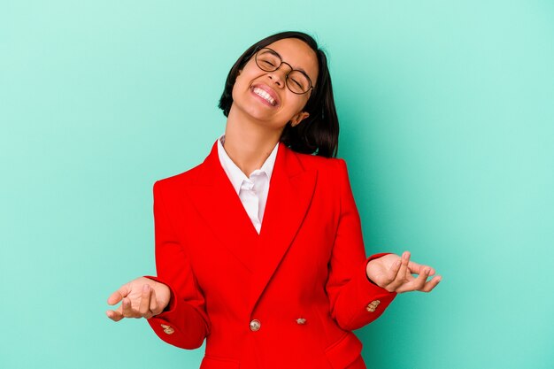 Mujer joven de raza mixta aislada sobre fondo azul relajado y feliz riendo, cuello estirado mostrando los dientes.