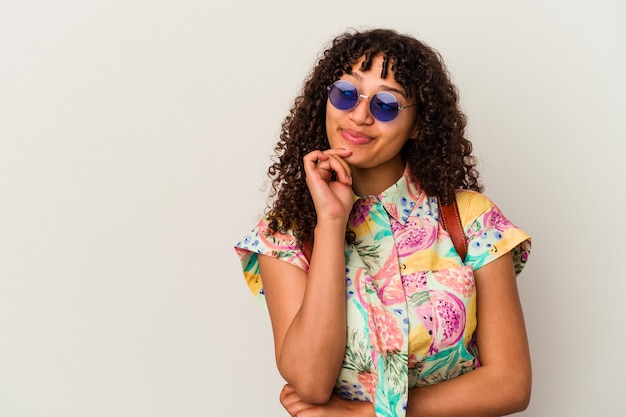 Mujer joven de raza mixta con gafas de sol tomando unas vacaciones aisladas mirando hacia los lados con expresión dudosa y escéptica.