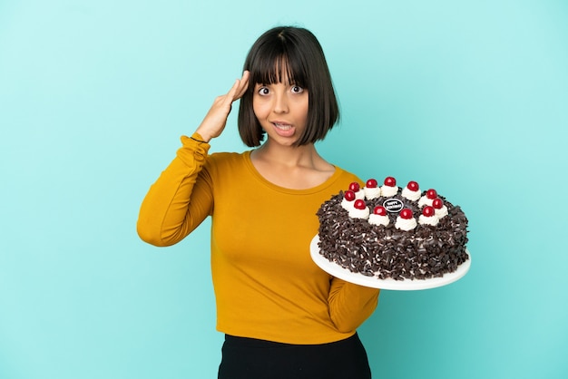 Mujer joven de raza mixta sosteniendo pastel de cumpleaños se ha dado cuenta de algo y tiene la intención de la solución