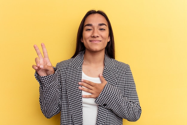 Mujer joven de raza mixta tomando un juramento, poniendo la mano en el pecho.