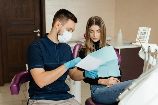 Una mujer joven en la recepción del dentista examina la imagen.