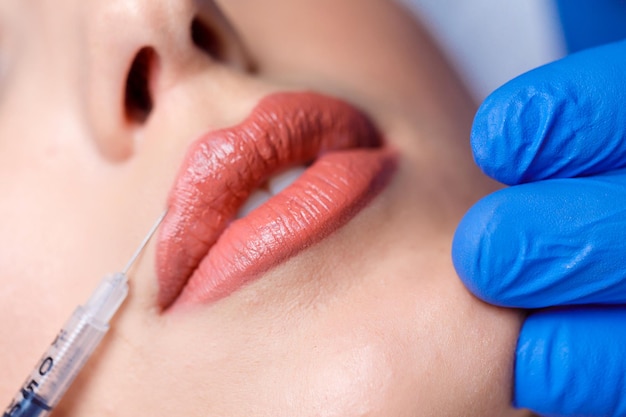 Mujer joven recibe inyección de botox en sus labios. Mujer en salón de belleza. clinica de cirugia plastica.