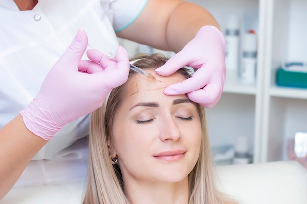 Mujer joven recibiendo inyección cosmética. mujer en un salon de belleza