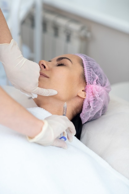 Mujer joven recibiendo un procedimiento facial en una clínica