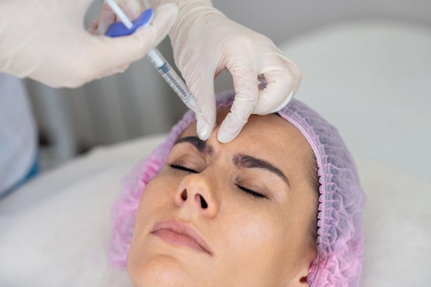 Mujer joven recibiendo un procedimiento facial en una clínica