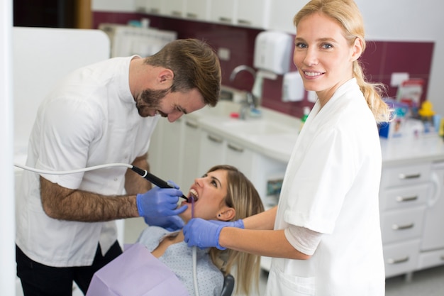 Mujer joven recibiendo tratamiento dental en la oficina del dentista