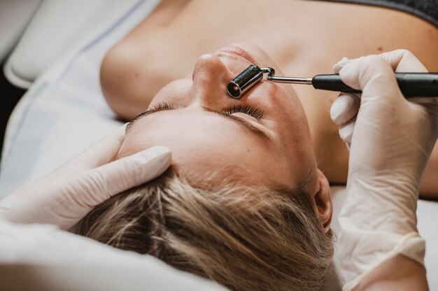 Mujer joven recibiendo un tratamiento facial en el spa