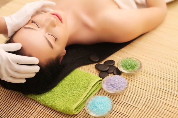 Mujer joven recibiendo tratamiento de spa en el salón de belleza spa masaje facial tratamiento de belleza facial salón de spa