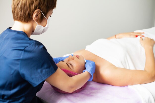 Mujer joven recibiendo tratamiento de spa en el salón de belleza