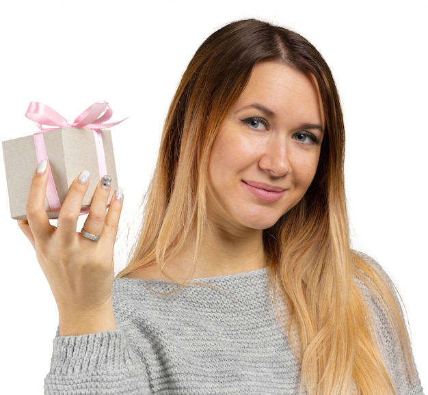 Mujer joven y regalo aislados en blanco