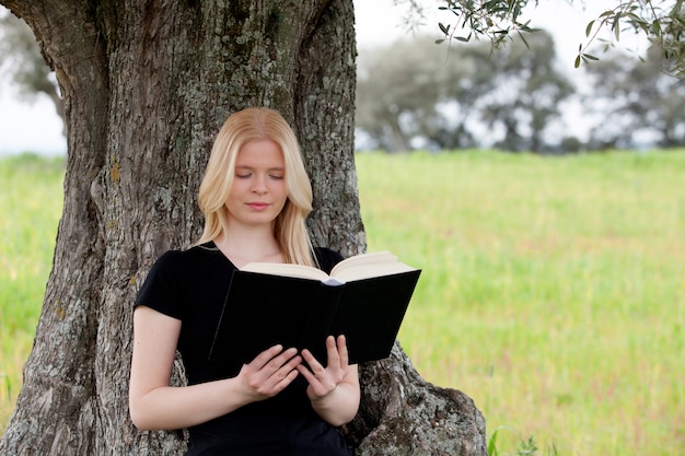 Mujer joven relajada leyendo un libro