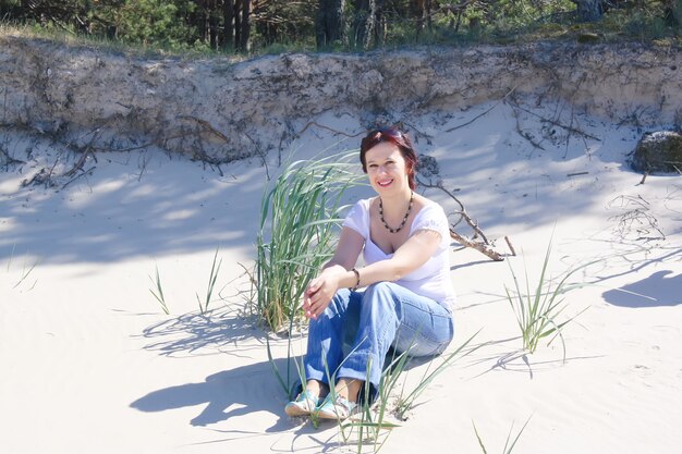 Mujer joven relajándose en una arena cerca del mar Báltico en un cálido día de primavera.