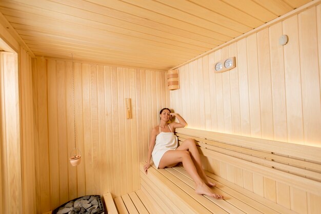 Mujer joven relajándose en la sauna