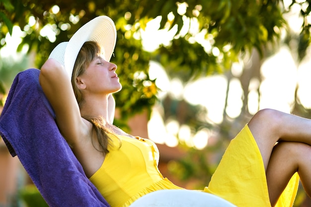 Mujer joven relajante al aire libre en un día soleado de verano.