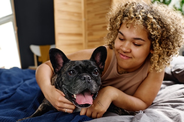 mujer joven, relajante, en cama, con, perro