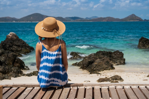 Mujer joven relajante y disfrutando en la playa tropical, vacaciones de verano y concepto de viaje