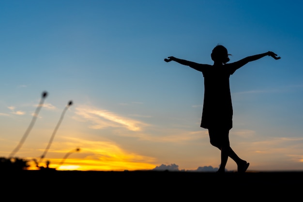 Mujer joven relajante con puesta de sol