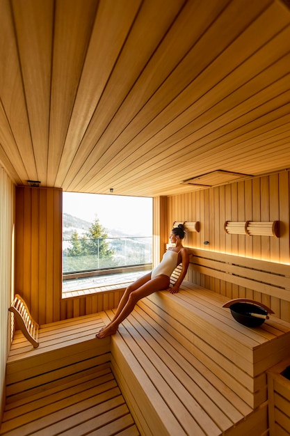 Mujer joven relajante en la sauna