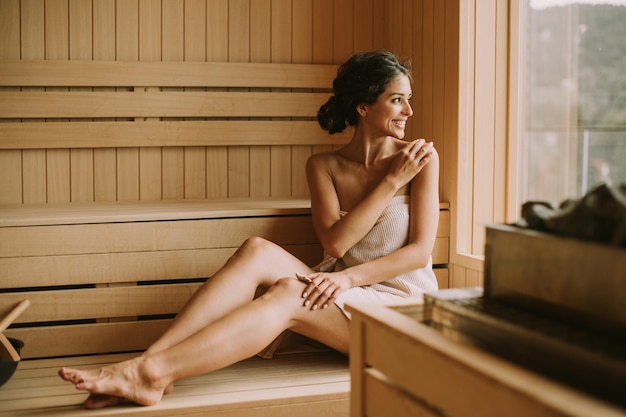 Mujer joven relajante en la sauna