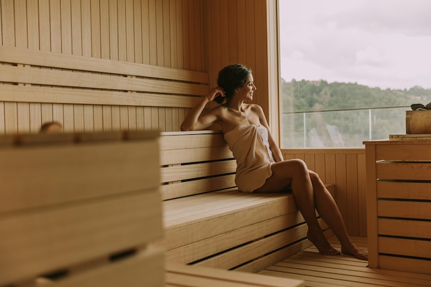 Mujer joven relajante en la sauna