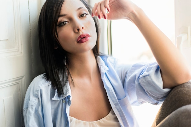 Mujer joven, relajante, por la ventana