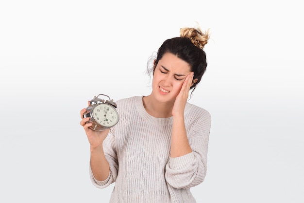 Mujer joven con reloj despertador.