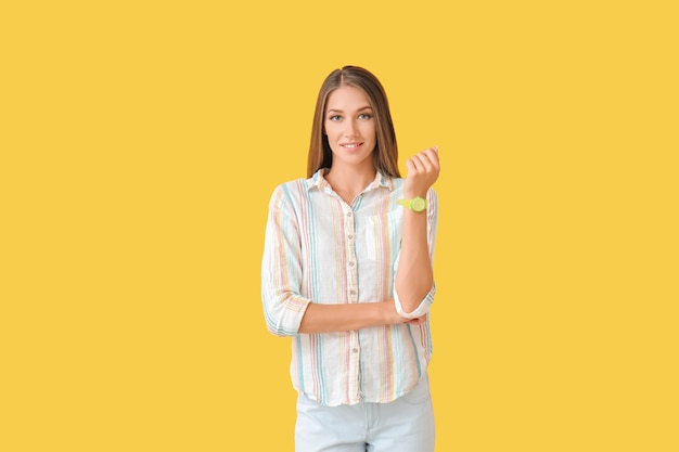 Mujer joven con reloj de pulsera en color