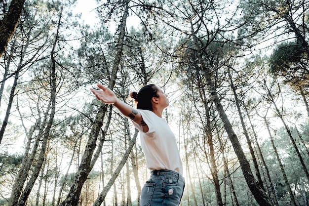 Mujer joven respirando aire limpio en la naturaleza forestFresh bienestar al aire libre concepto de estilo de vida saludable concepto de árboles para el medio ambiente calentamiento global estilo de vida saludable personas en la naturaleza sin contaminación