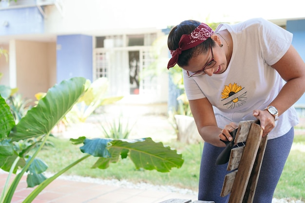 mujer joven, restauración, viejo, silla, aire libre, en, patio, trabajo