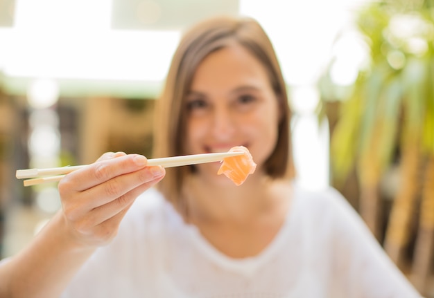 Foto mujer joven en un restaurante con sushi