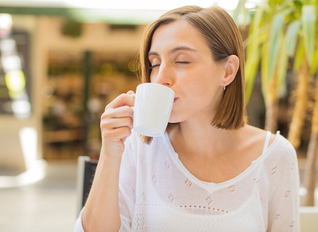 mujer joven en un restaurante tomando un café