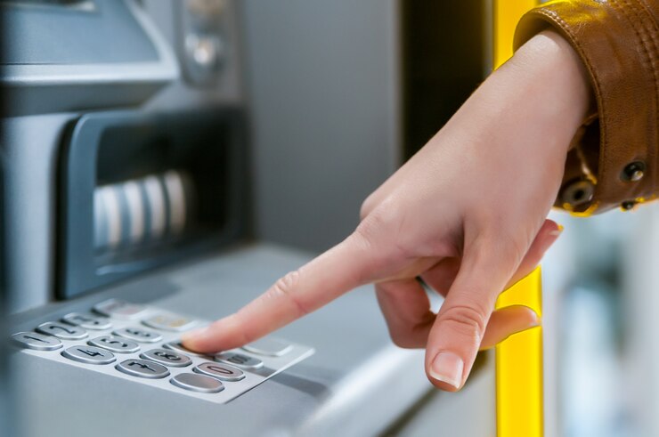 Mujer joven retirar dinero de la tarjeta de crédito en cajero automático