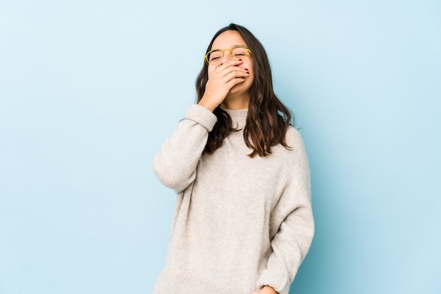 Mujer joven riendo aislado en azul