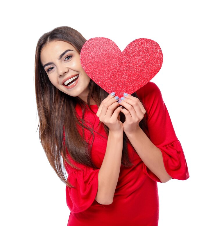 Foto mujer joven romántica con corazón de papel sobre fondo blanco.