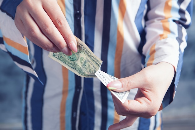 Foto mujer joven rompiendo un billete de un dólar