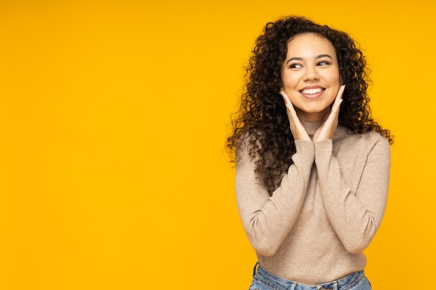 Mujer joven en ropa casual sobre fondo amarillo