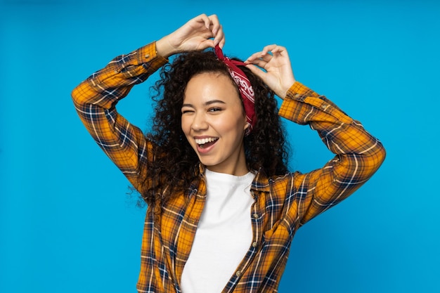 Mujer joven en ropa casual sobre fondo azul.