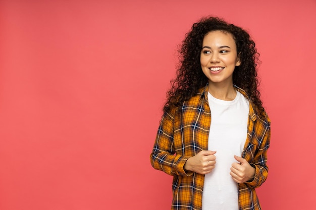 Mujer joven en ropa casual sobre fondo rosa