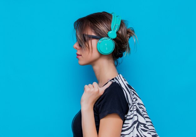 Mujer joven en ropa de cebra y auriculares en azul