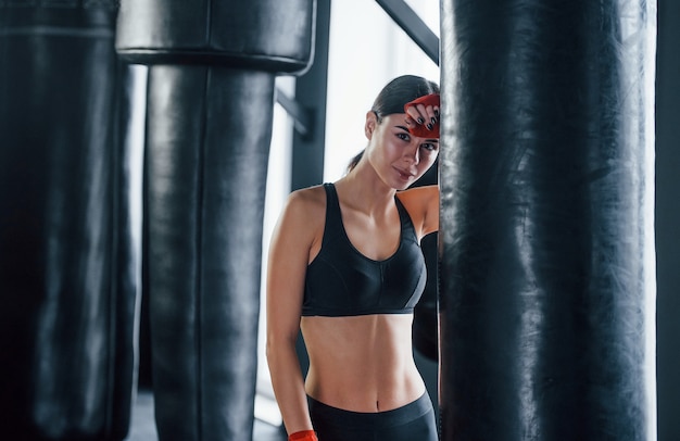 Mujer joven en ropa deportiva está en el gimnasio con día de ejercicio. Concepción del boxeo.