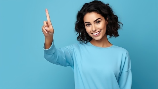 Mujer joven con ropa informal apuntando con la mano y el dedo hacia un lado sobre fondo azul