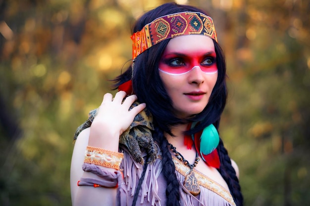 Mujer joven con ropa tradicional llevando tortuga en el bosque