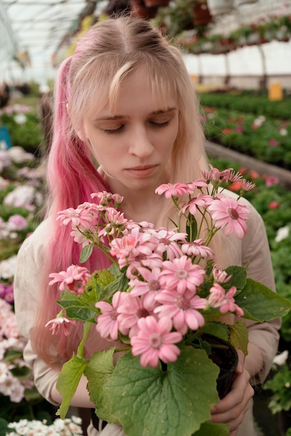 mujer joven, con, rosa, y, rubio, pelo, tenencia, rosa, flores, en, jardín