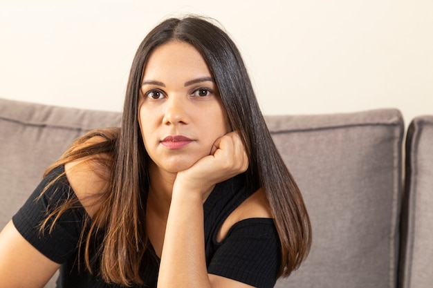 Mujer joven con rostro serio y pensativo.